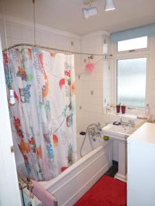 a bathroom with a tub and a shower curtain at House o' Books in London