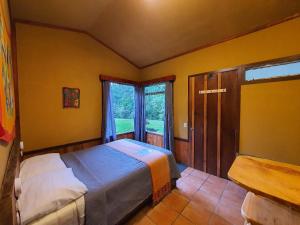 a bedroom with a bed and a large window at Finca Terra Viva in Monteverde Costa Rica
