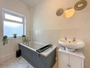 a bathroom with a sink and a bath tub and a sink at Luxe & Stylish 1 Bed Flat in London