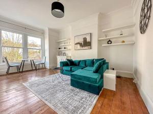 a living room with a green couch and a table at Luxe & Stylish 1 Bed Flat in London