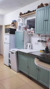 a kitchen with blue cabinets and white appliances at Privát Voyage in Liptovský Mikuláš
