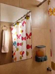 baño con cortina de ducha con mariposas. en La Algarroba en Alta Gracia