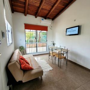 ein Wohnzimmer mit einem Sofa und einem Tisch in der Unterkunft La Algarroba in Alta Gracia