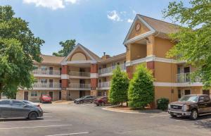 a large apartment building with cars parked in a parking lot at Extended Stay America Suites - Greensboro - Wendover Ave - Big Tree Way in Greensboro