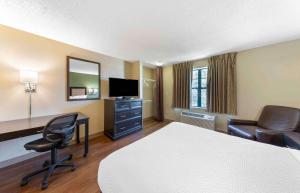 a hotel room with a bed and a desk and chair at Extended Stay America Suites - Greensboro - Wendover Ave - Big Tree Way in Greensboro