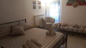 a bedroom with two beds and a chair at Appartamento Casa Margi in Ameglia