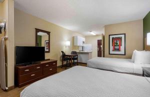 a hotel room with two beds and a flat screen tv at Extended Stay America Suites - Laredo - Del Mar in Laredo