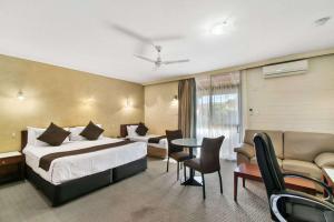 a hotel room with a bed and a table and chairs at Comfort Inn Whyalla in Whyalla