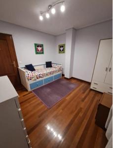 1 dormitorio con 1 cama en una habitación con suelo de madera en Casa bella alma, en Ramales de la Victoria