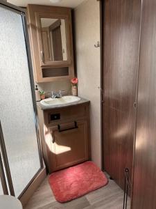 a small bathroom with a sink and a mirror at Gorgeous Denali 5th Wheel Delight! in Walla Walla