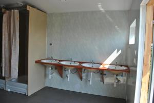 a row of four sinks in a bathroom at Camping - Park Władysławowo in Władysławowo