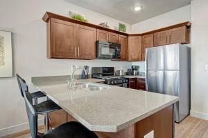 a kitchen with a stainless steel refrigerator and wooden cabinets at Luxury Condo in the Library Square District in Salt Lake City