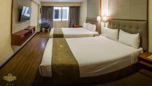 a hotel room with two beds and a television at Hotel Boutique Candamo in Lima