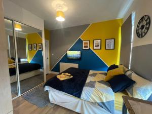a bedroom with a blue and yellow wall at The Oxford Avenue in Southampton