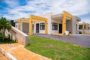 a house with yellow columns and a yard at Hey Love in Ocho Rios