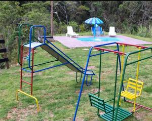 um parque infantil com um escorrega num quintal em Sitio recanto Feliz em Mariana