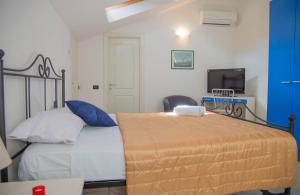una camera da letto con un letto con pareti blu e una TV di La Spezia Vezzano 5 terre - Il Ciliegio a Vezzano Ligure