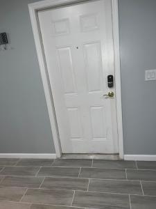 een witte deur in een kamer met een tegelvloer bij Cozy Inspired Studio Apartment in Newark