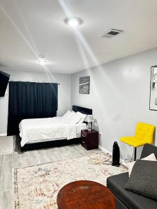 een slaapkamer met een bed, een bank en een tafel bij Cozy Inspired Studio Apartment in Newark