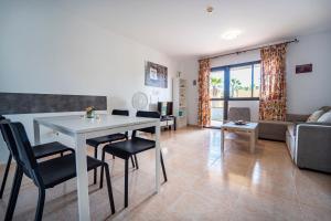 a living room with a table and chairs and a couch at Oasis Fuerteventura in Corralejo
