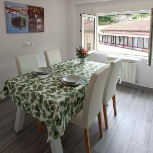 a dining room table with a green and white table cloth at Las Gaviotas Cudillero in Cudillero