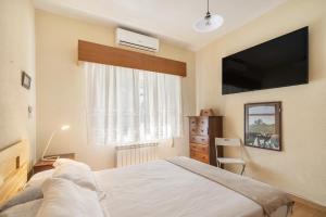 1 dormitorio con 1 cama y TV de pantalla plana en Casa Rural Los Olivos de Robledo de Chavela, en La Estación