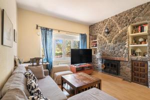 sala de estar con sofá y chimenea en Casa Rural Los Olivos de Robledo de Chavela, en La Estación