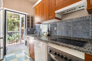 a kitchen with a sink and a dishwasher at Casa Rural Los Olivos de Robledo de Chavela in La Estación