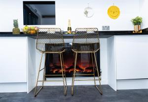 2 sillas sentadas en una barra de cocina con chimenea en TD Carsh Wolverhampton - Luxurious 2 Bed House - Sleeps 6 - Perfect for Long Stay Workers - Leisure - Families en Wolverhampton