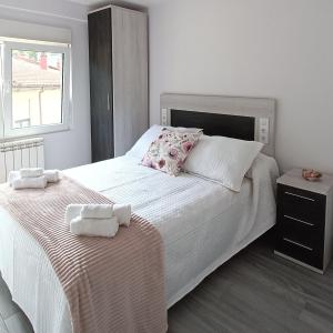 a bedroom with a large white bed with towels on it at Las Gaviotas Cudillero in Cudillero