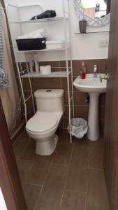 La salle de bains est pourvue de toilettes et d'un lavabo. dans l'établissement Hermoso hogar con bbq y piscina en Punta Blanca, à Punta Blanca