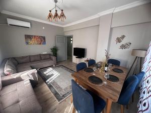 sala de estar con mesa de madera y sillas azules en 300 meters to Konyaaltı beach 2+1 large and spacious apartment, en Antalya
