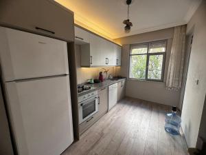 cocina con nevera blanca y ventana en 300 meters to Konyaaltı beach 2+1 large and spacious apartment, en Antalya