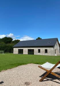 a building with a black roof with a bench in front of it at luxury pod with hot tub in Clodock