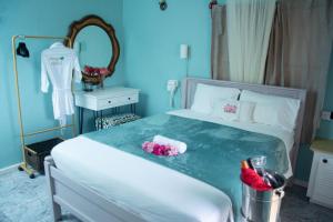 Dormitorio azul con cama y espejo en Mountain View Apartments, en Gros Islet