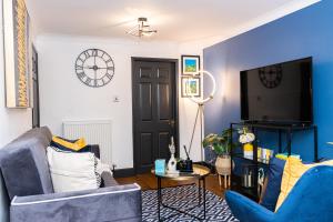 ein Wohnzimmer mit blauen Wänden und einem TV in der Unterkunft TD Carsh Wolverhampton - Luxurious 2 Bed House - Sleeps 6 - Perfect for Long Stay Workers - Leisure - Families in Wolverhampton