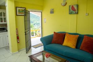 a living room with a blue couch and a table at Mountain View Apartments in Gros Islet