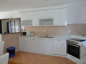 a kitchen with white cabinets and a sink at Apartment Mira in Senj +24 photos