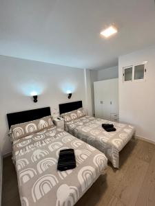 two beds in a room with two beds sidx sidx sidx at Ducado 41 Playa in Benidorm