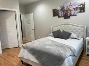 a bedroom with a white bed with two pillows at La Casa Grande Hosting in Whitsett