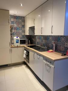 a kitchen with white cabinets and a counter top at Mieszkanie z ogródkiem in Wrocław