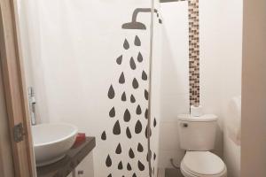 a bathroom with a white toilet and a sink at LOVENEST in Lima