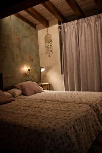 a bedroom with a bed and a window at Susurros del Manadero in Robledillo de Gata