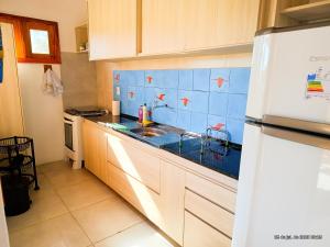 a kitchen with a sink and blue tiles on the wall at Flats Macapá Meu Amor in Luis Correia