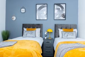 2 camas en un dormitorio con paredes azules en TD Carsh Wolverhampton - Luxurious 2 Bed House - Sleeps 6 - Perfect for Long Stay Workers - Leisure - Families en Wolverhampton