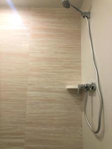 een douche met een douchekop in de badkamer bij Breeze Homstay in Tile Hill