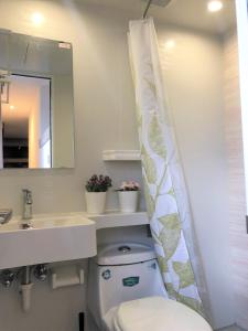 y baño con aseo, lavamanos y cortina de ducha. en Breeze Homstay en Tile Hill