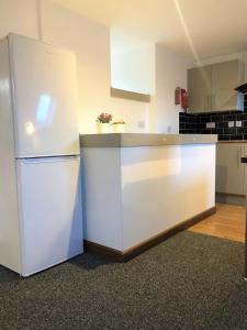 a kitchen with a white refrigerator in a room at Breeze Homstay in Tile Hill