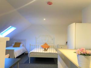 a small bedroom with a bed and a refrigerator at Breeze Homstay in Tile Hill