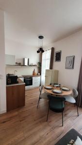 Appartement au calme T3 RDC - Quartier de France في فيشي: غرفة معيشة مع طاولة ومطبخ